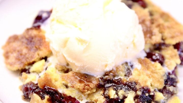 blackberry dump cake with ice cream on a plate.