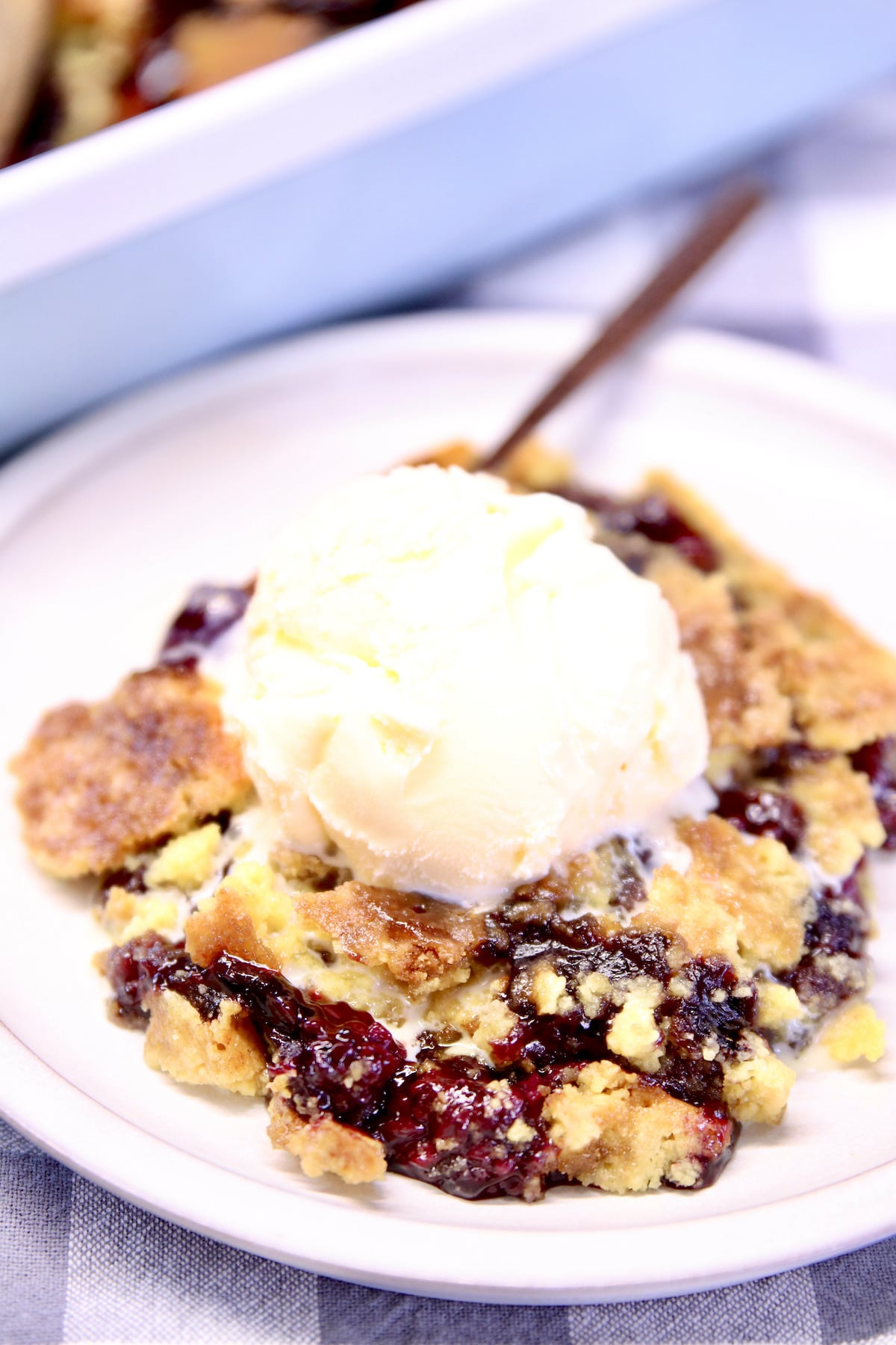 Blackberry Dump Cake on a plate with ice cream