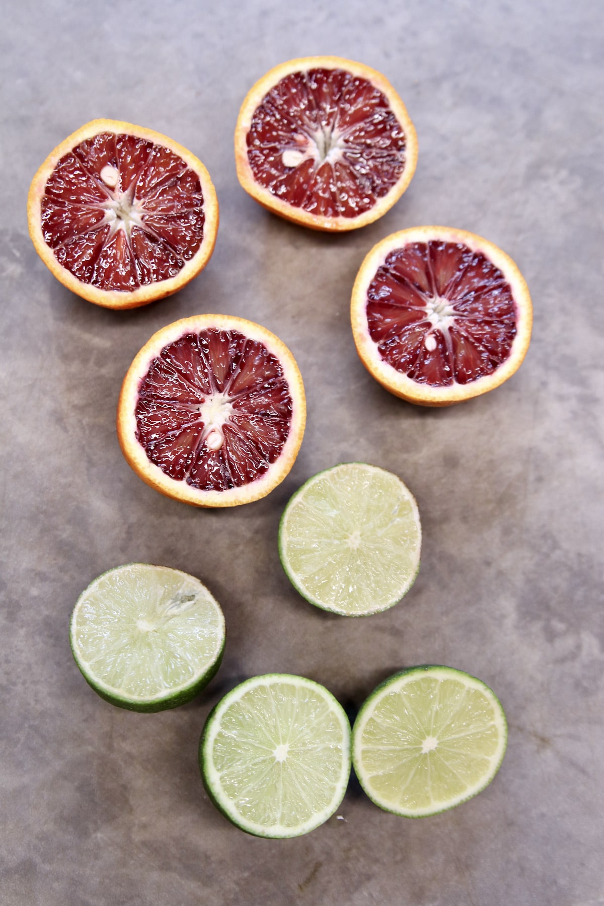 Blood oranges and limes on a cutting board.