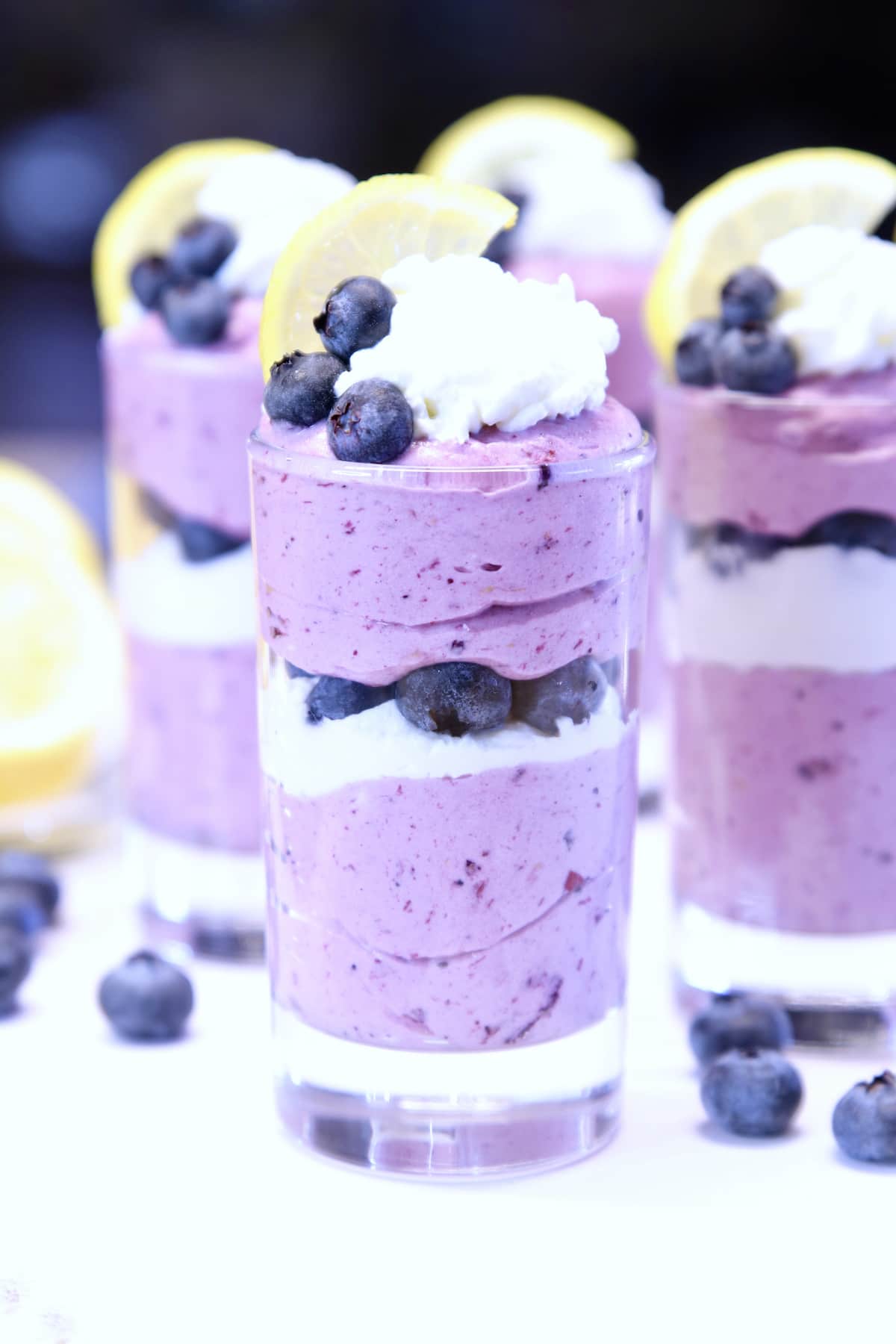 Blueberry Cheesecake - no bake dessert in juice glasses with blueberries and lemon garnish.