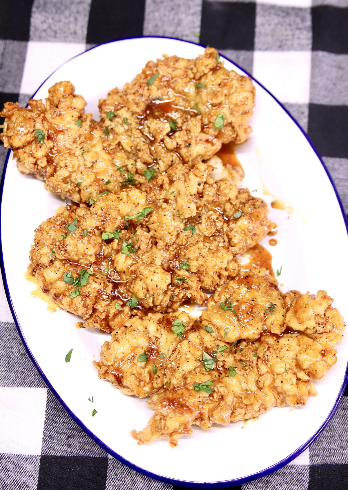 Crispy chicken tenders with honey garlic sauce on a platter.