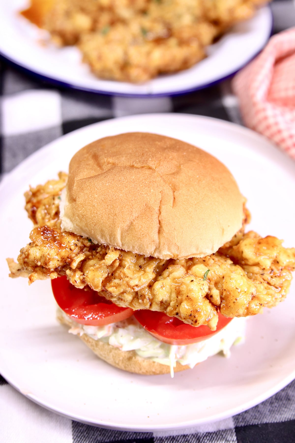 Crispy chicken tender sandwich with slaw and sliced tomatoes.