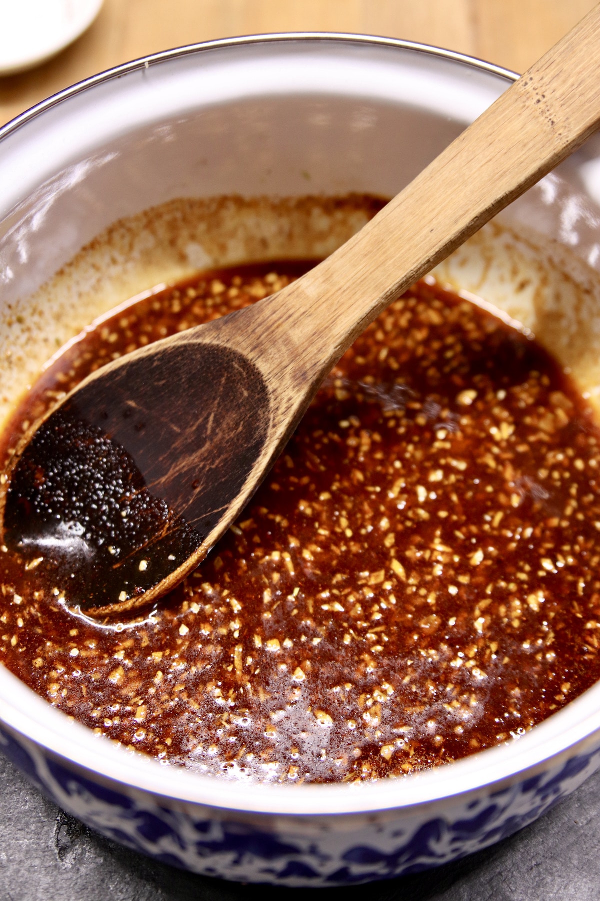honey garlic sauce in a pan with wooden spoon.
