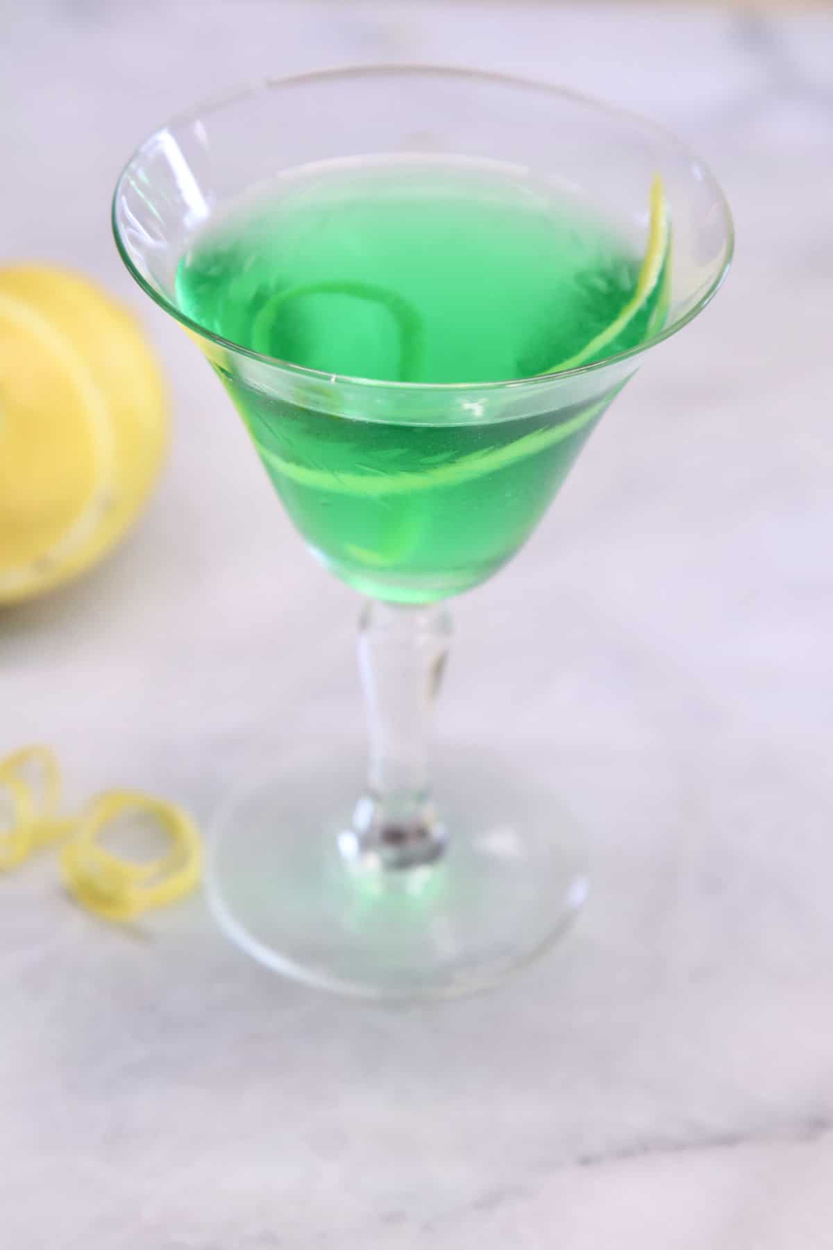Irish Martini - green cocktail with lemon garnish.