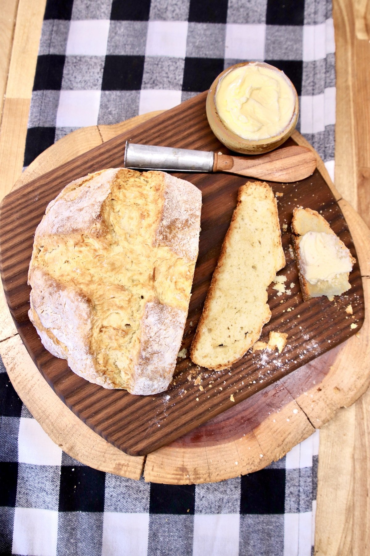 Irish Soda Bread, one slice on a cutting board, bowl of butter, knife.