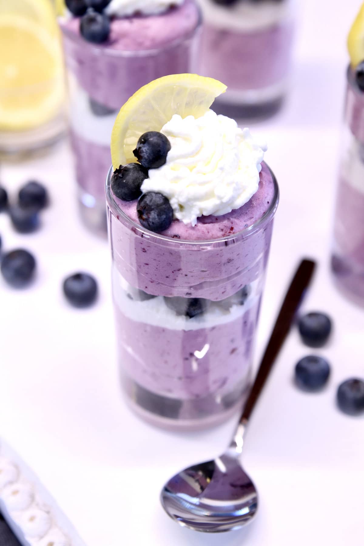blueberry cheesecake in a glass with whipped cream.