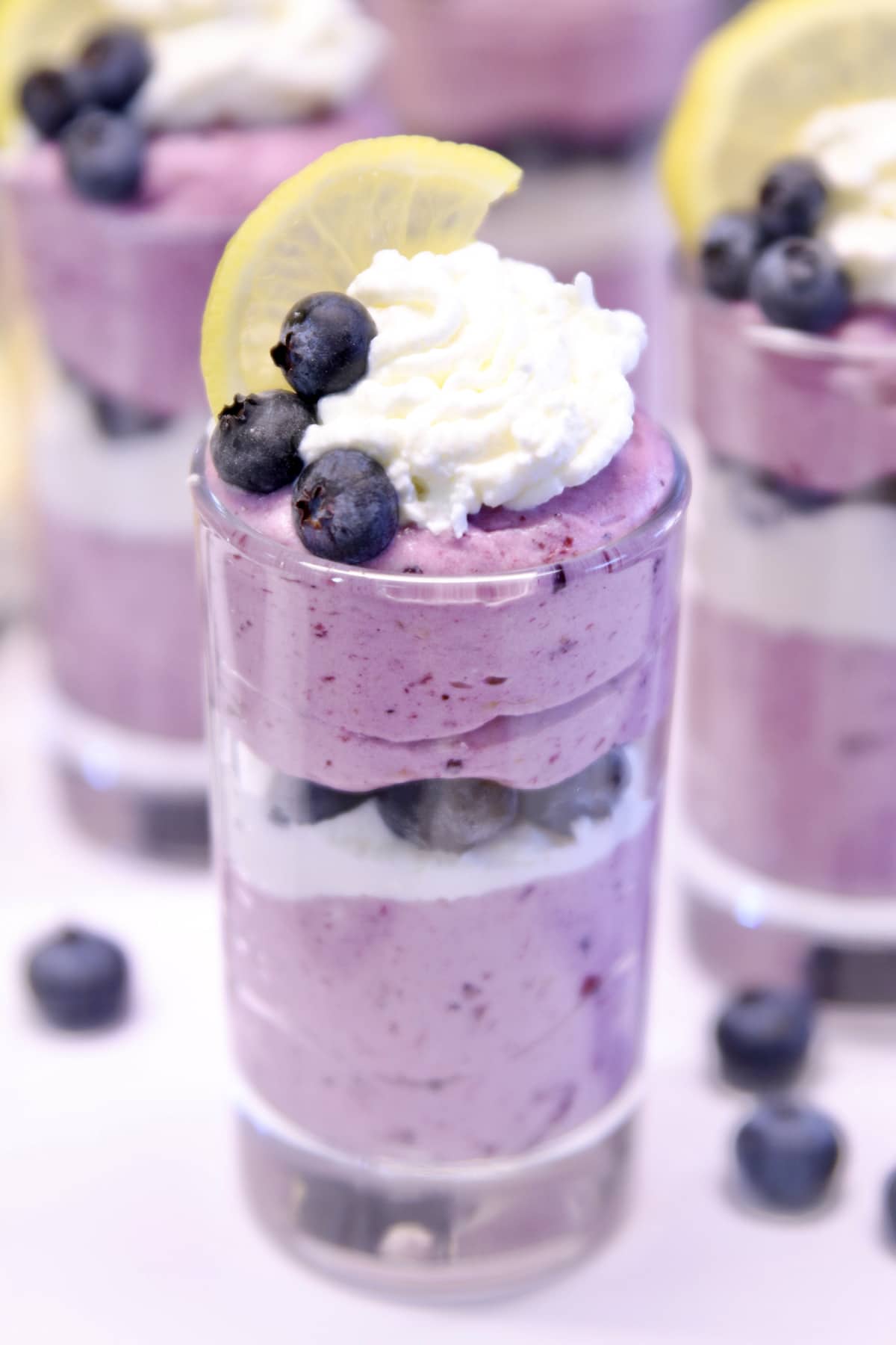 dessert glass with layered blueberry lemon cheesecake.