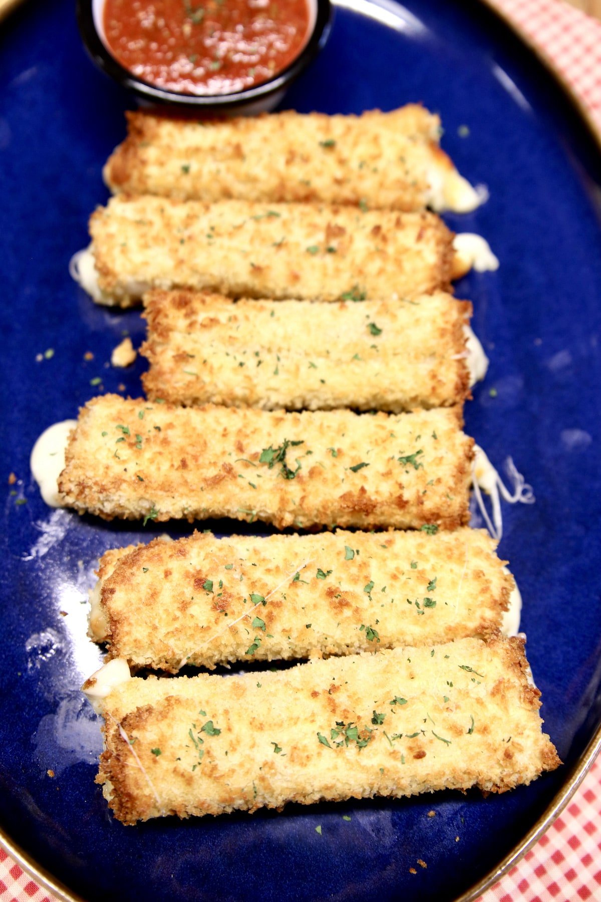 Homemade cheese sticks on a platter with marinara.