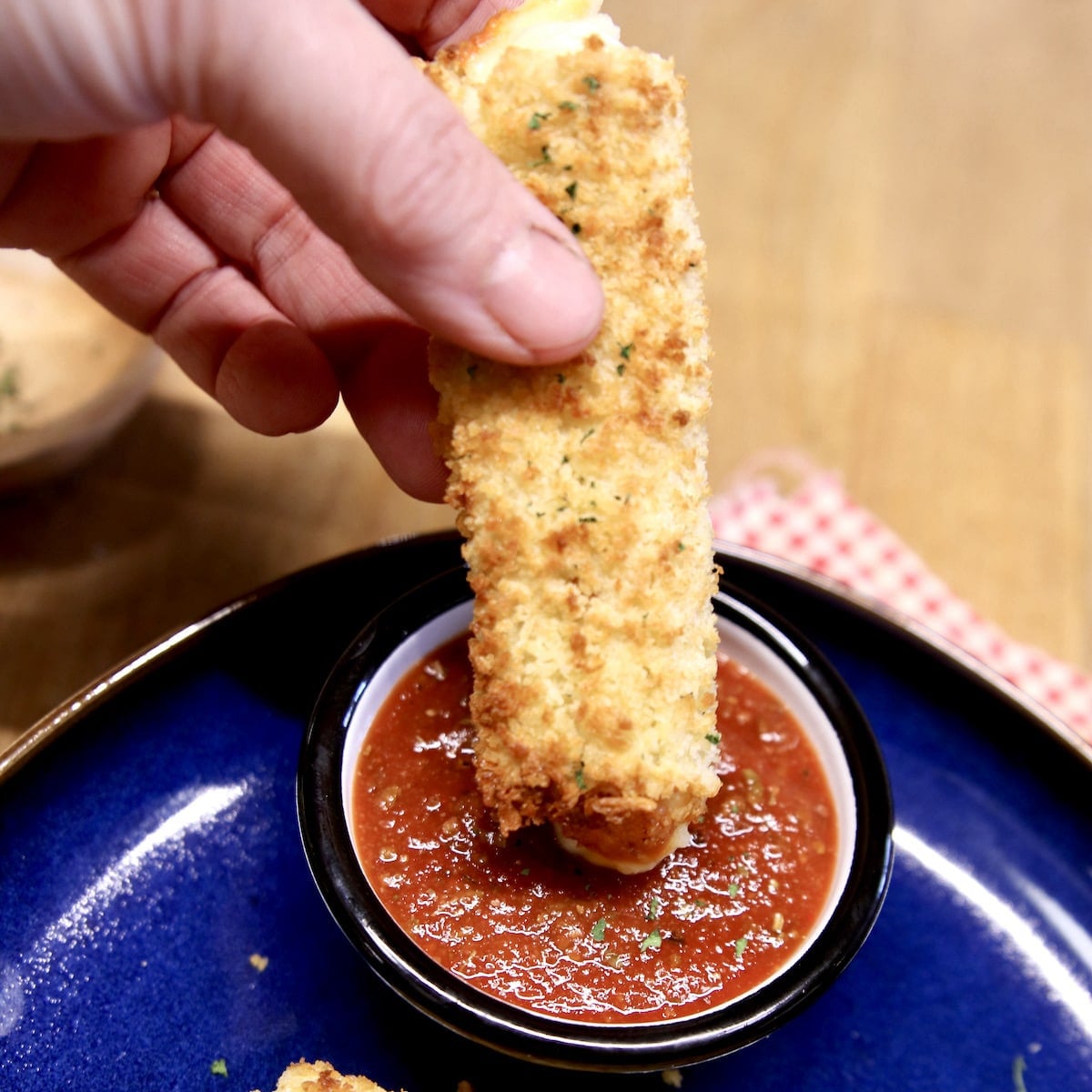 Mozzarella stick dipping in marinara