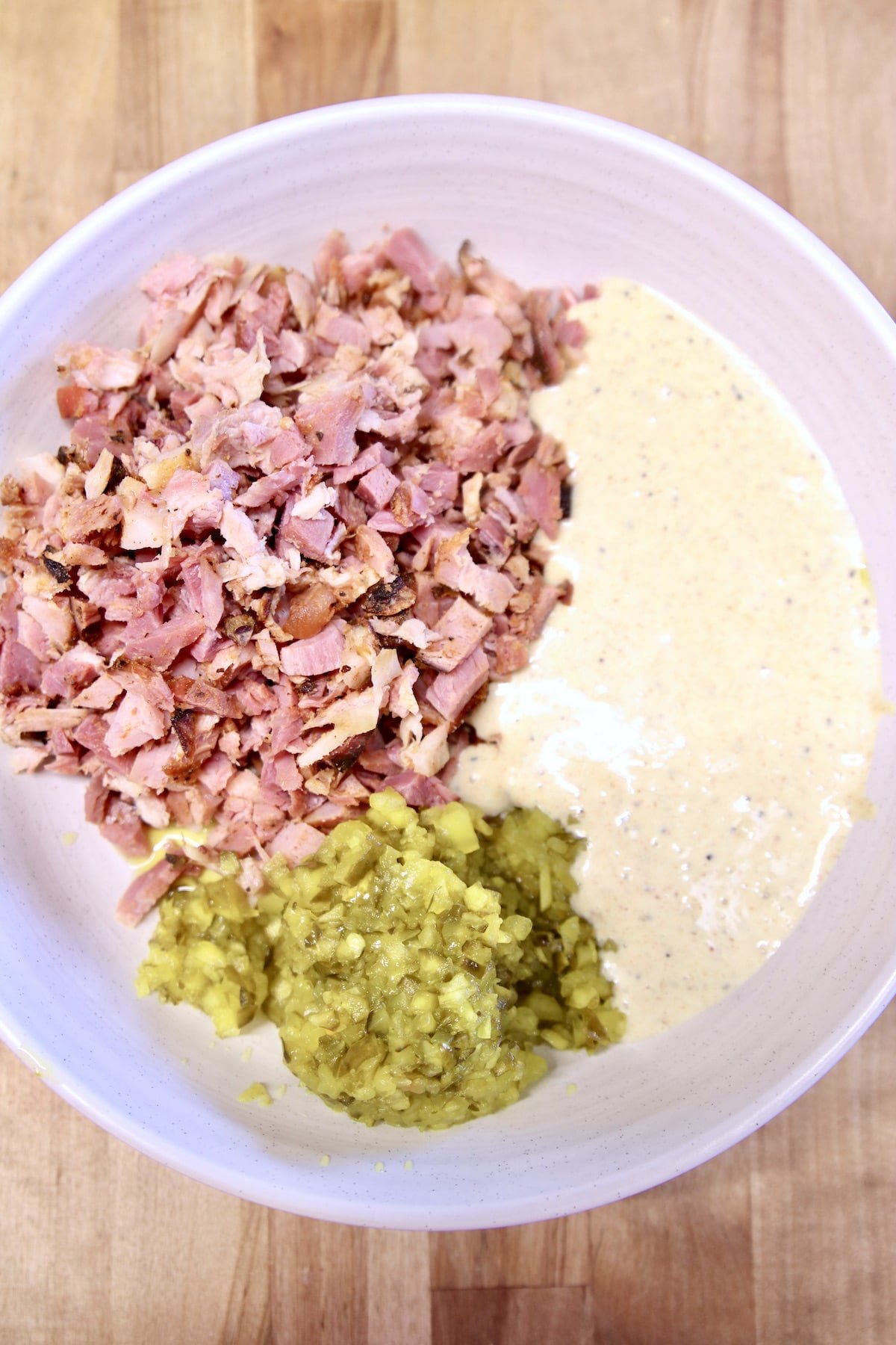bowl with chopped ham, pickle relish and dressing.