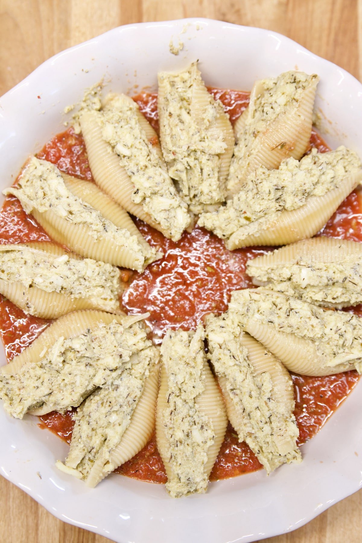 pie dish with stuffed pasta shells and tomato sauce.