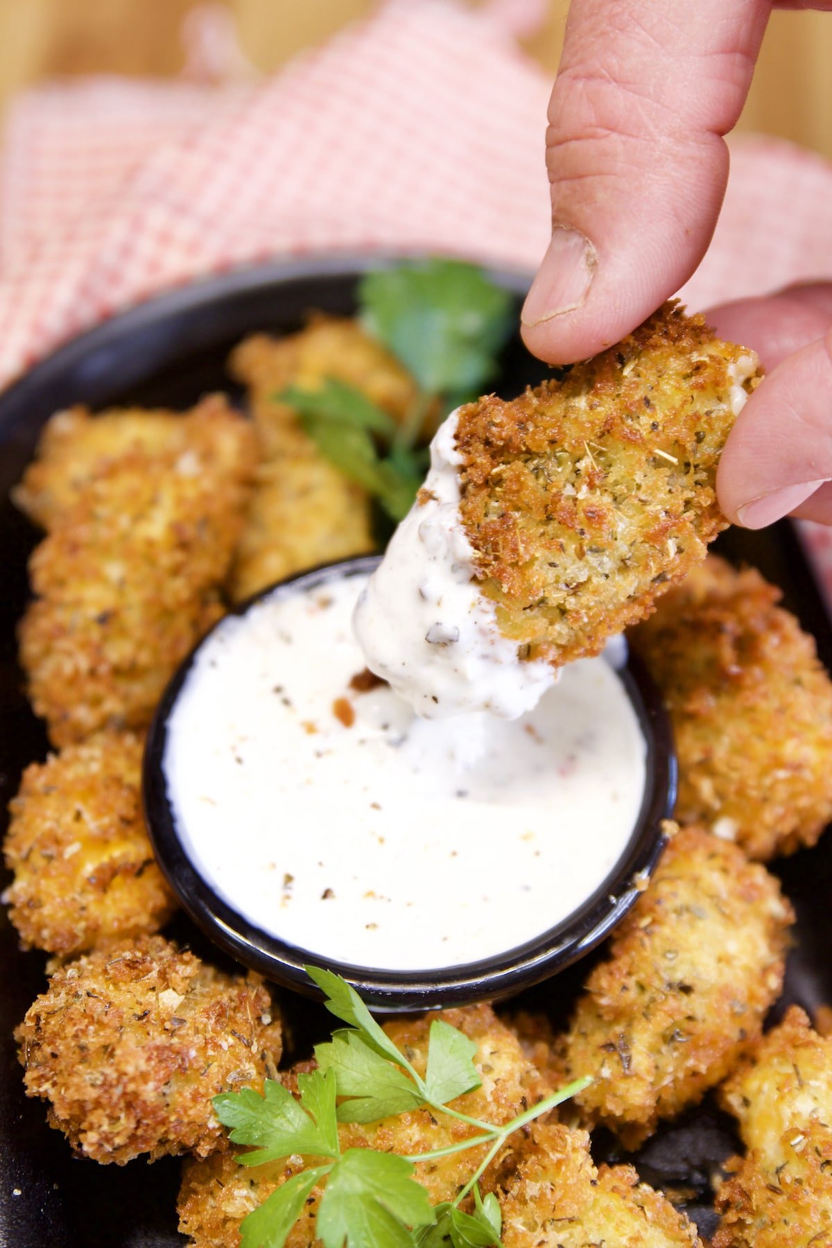 Fried cheese curd dipping into ranch.