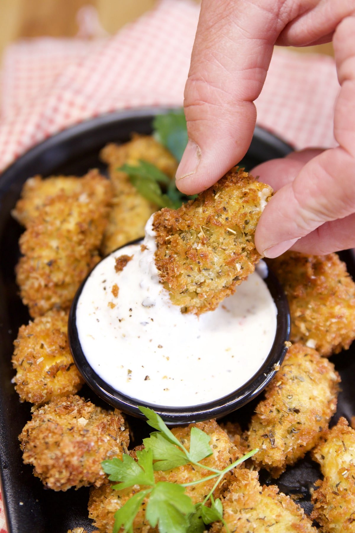 Dipping fried cheese curd in ranch.