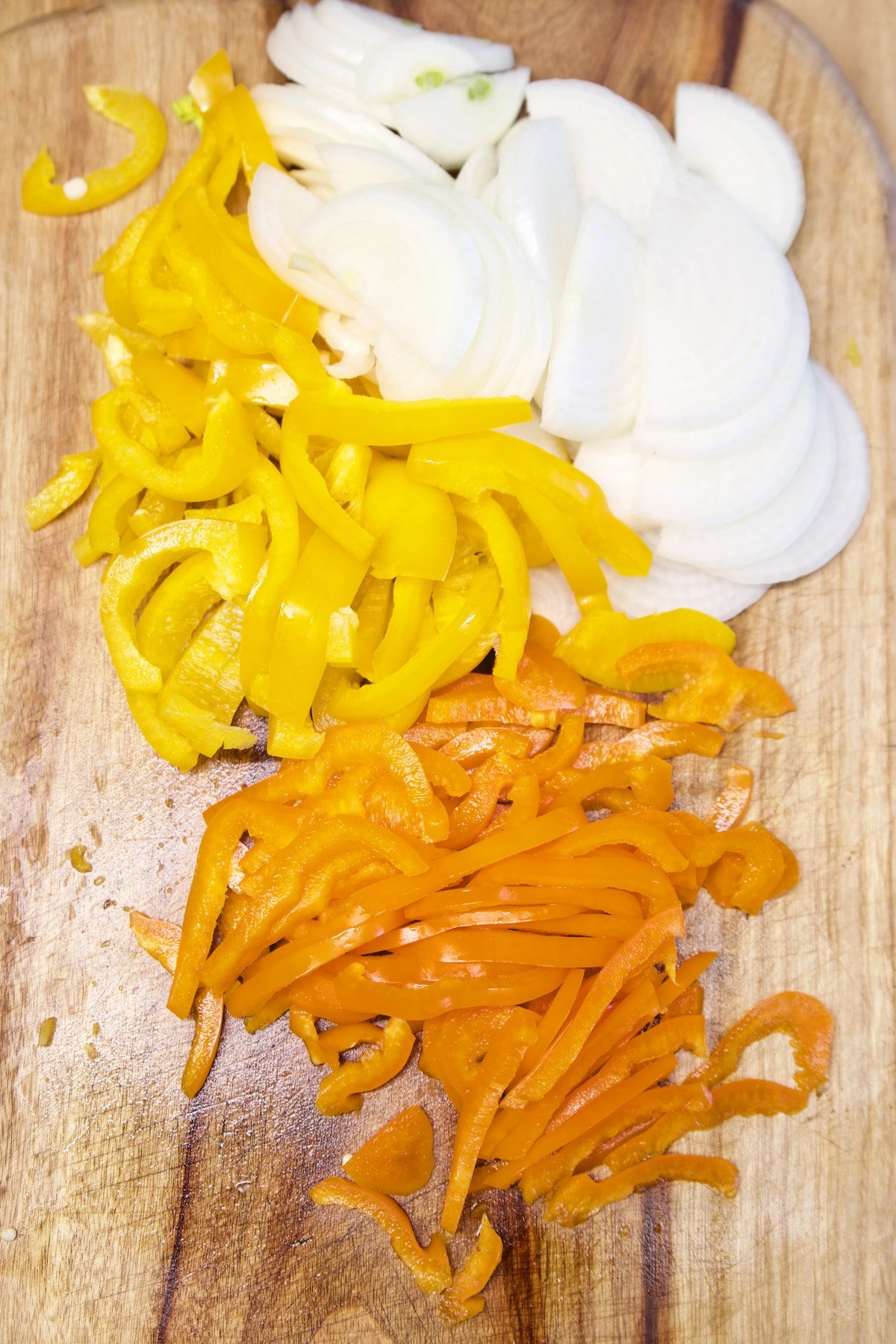 Sliced yellow and orange bell peppers, onions.