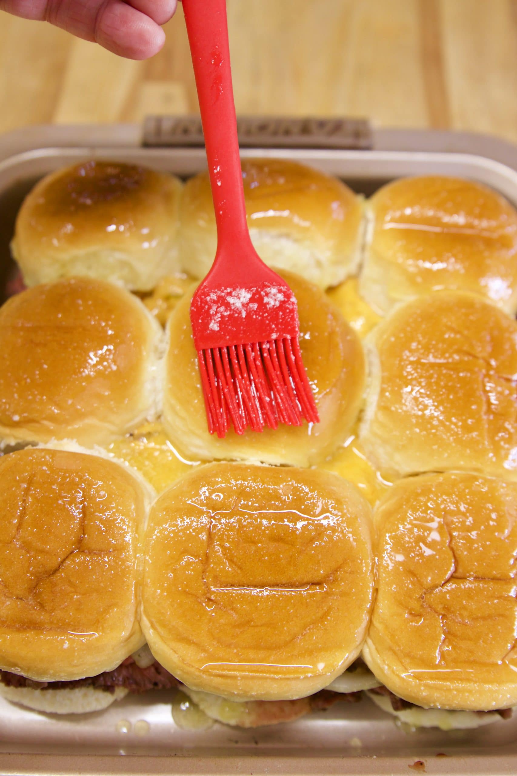 Brushing butter over slider buns.