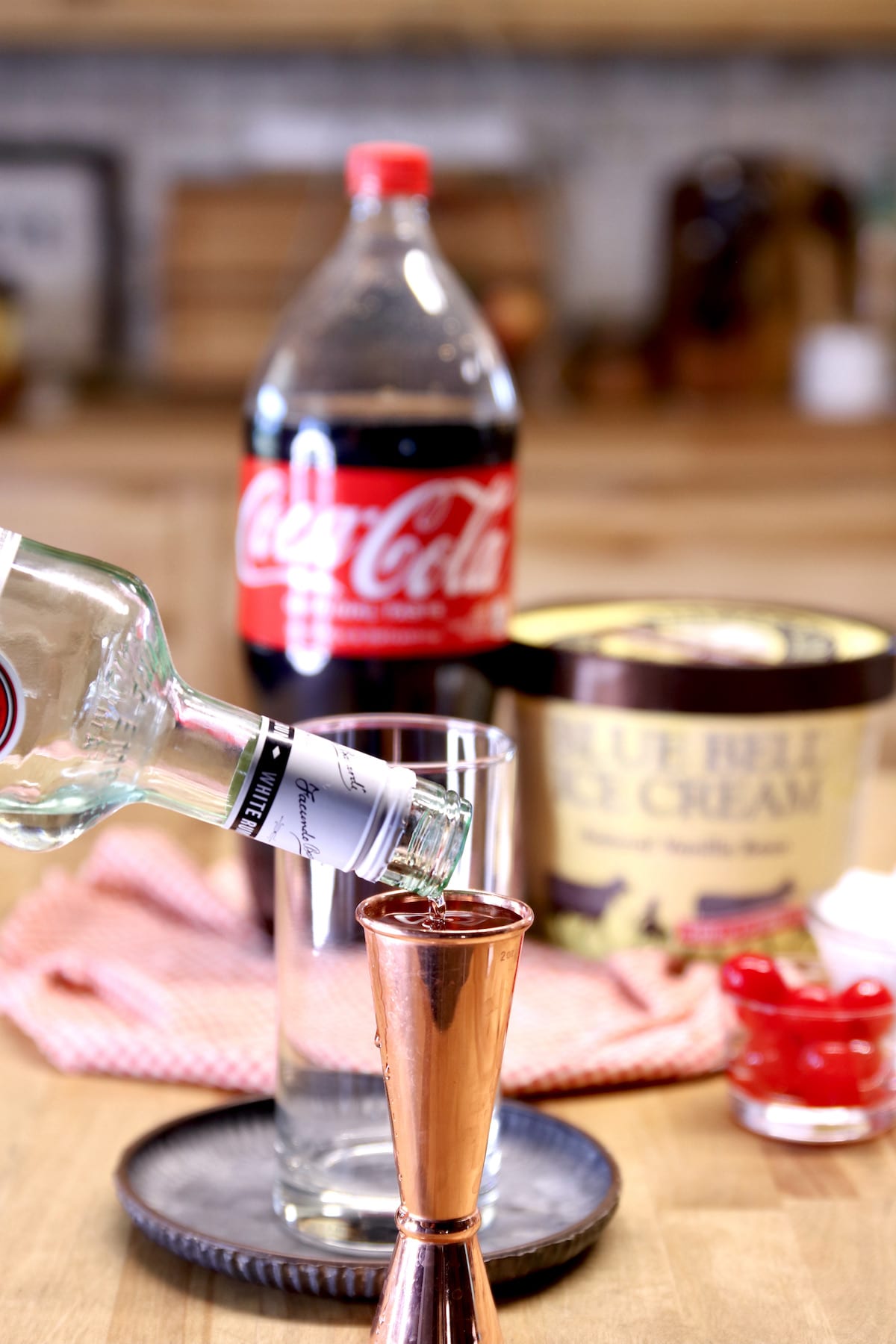Pouring rum into a cocktail jigger.