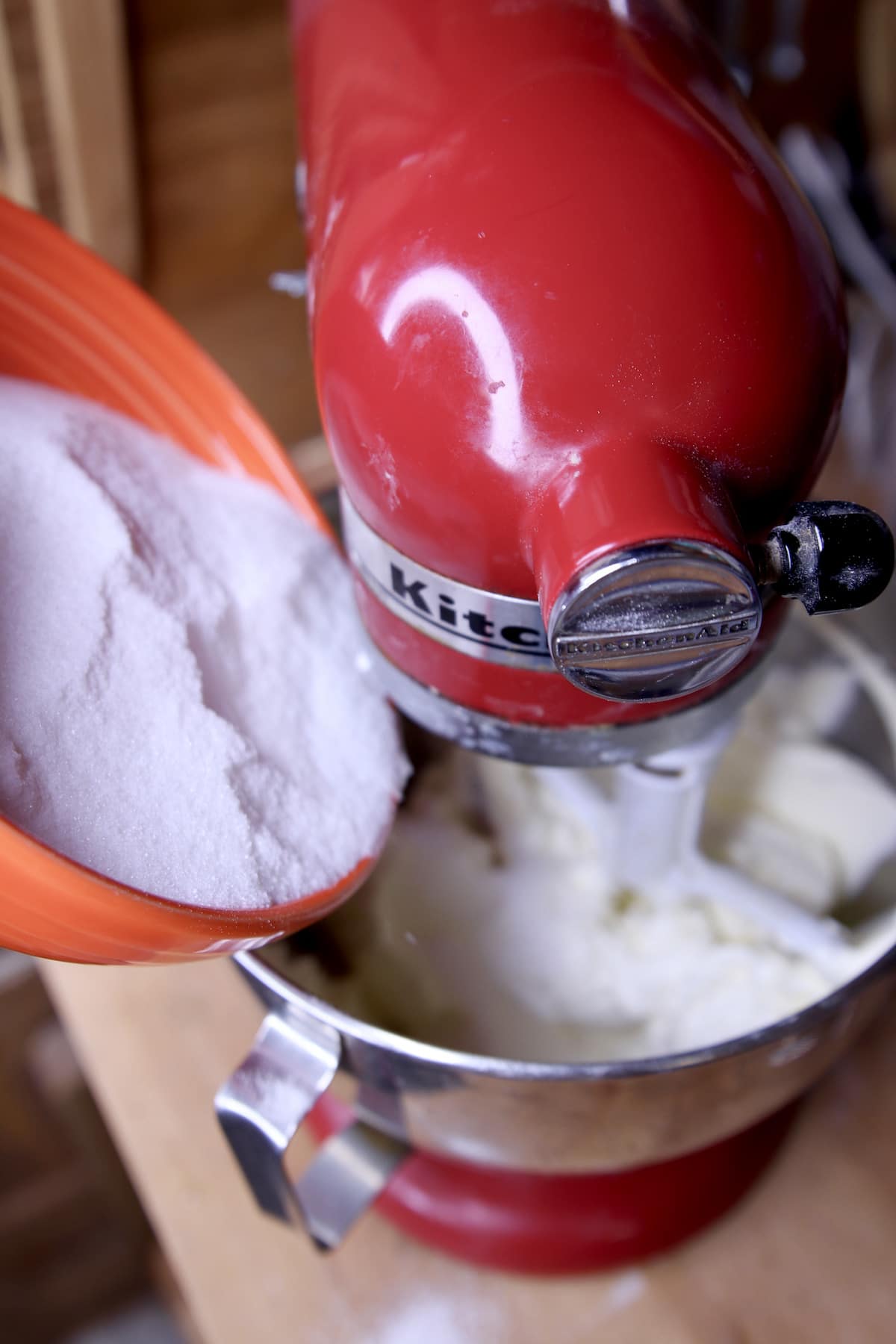 Adding sugar to mixer bowl.