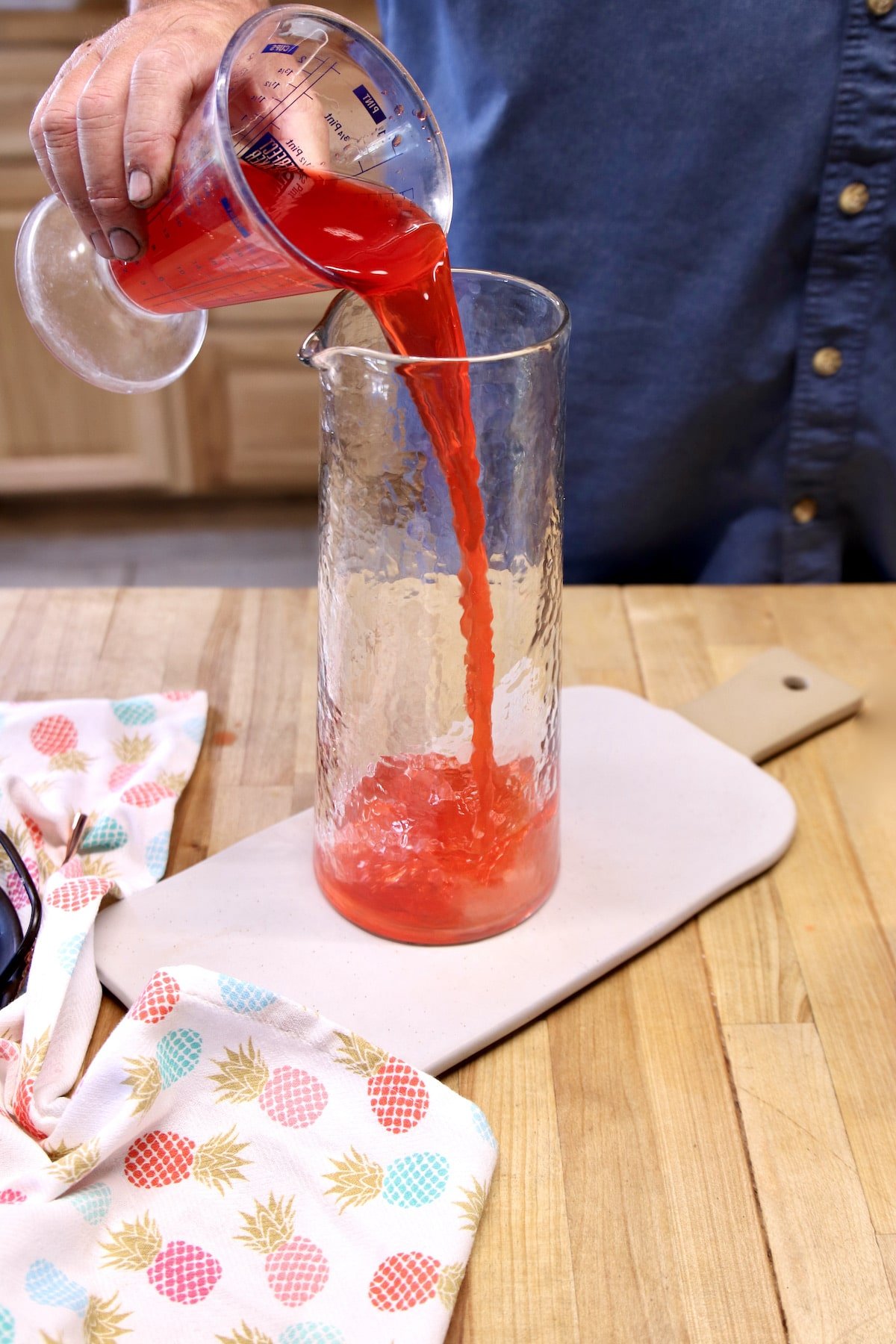 Pouring Hawaiian Punch into a pitcher.