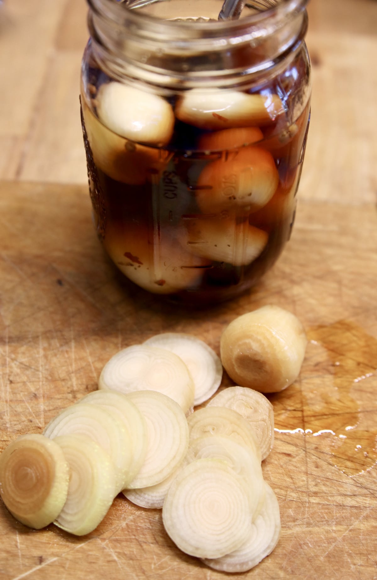 Sliced pickled onions with jar.