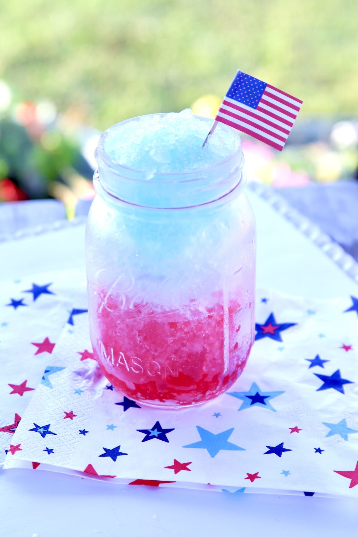 Red white and blue slush in a mason jar. American flag garnish.