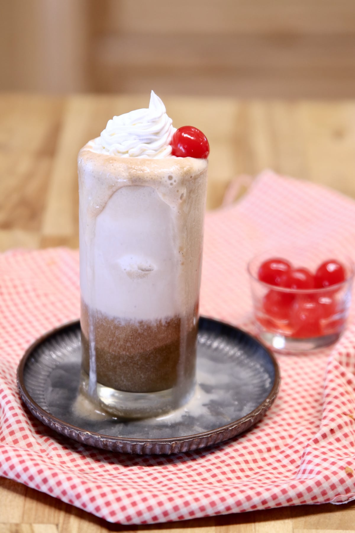 Coke float with whipped cream and cherry on top.