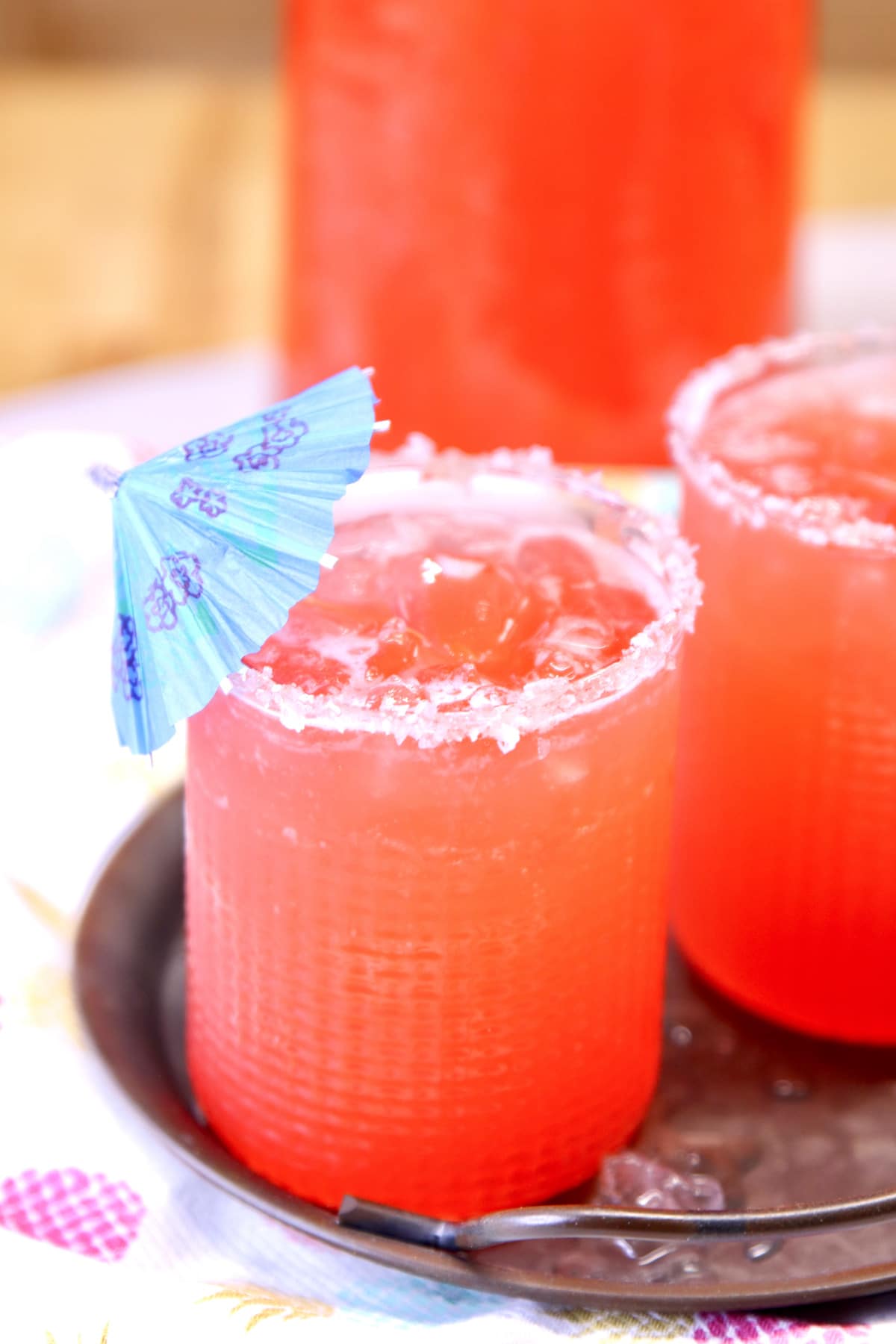 Tequila Punch in a glass with salt rim and drink umbrella.