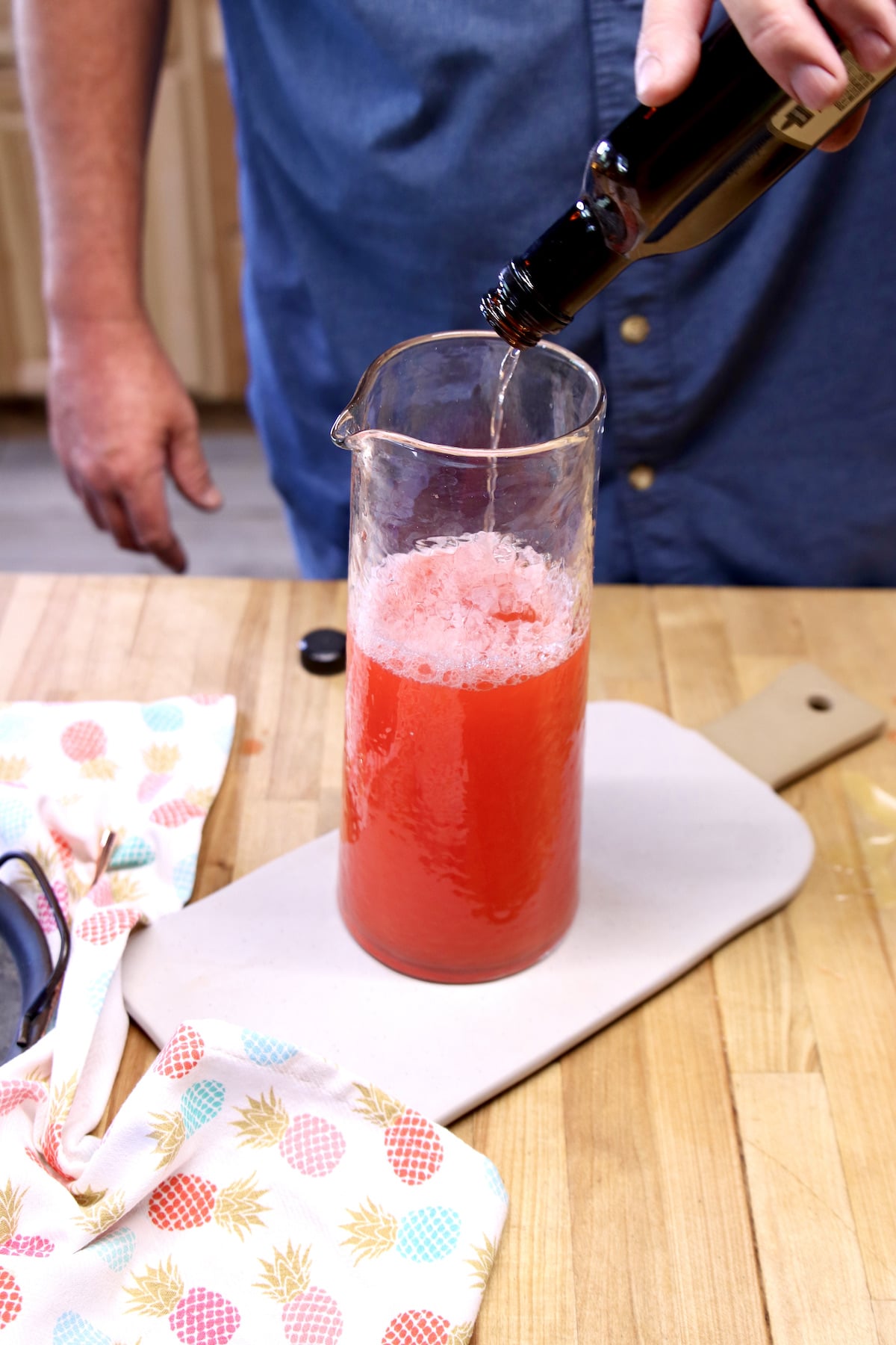Adding triple sec to party punch.