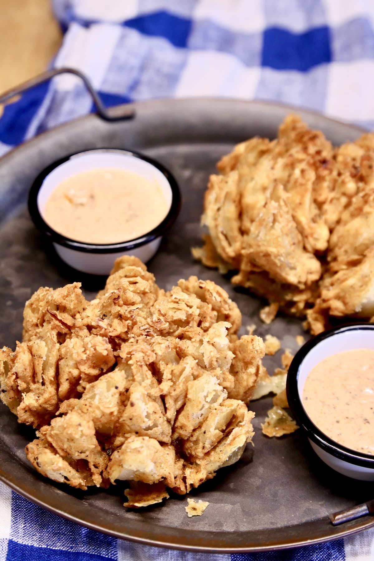 Blooming onions and sauce on a platter.
