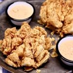 Blooming Onions with sauce on a platter.