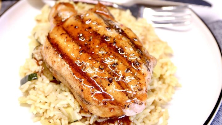 Honey garlic grilled pork chop on a plate with rice.