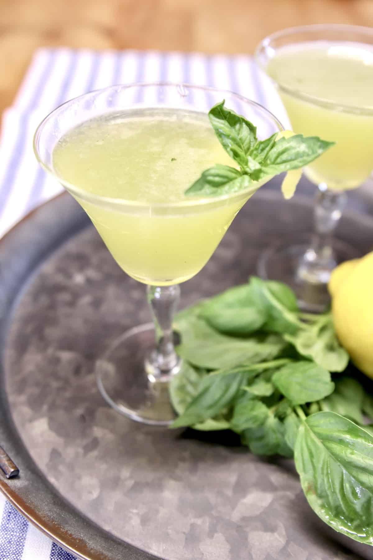 Coupe glass with lemon basil and gin cocktail.