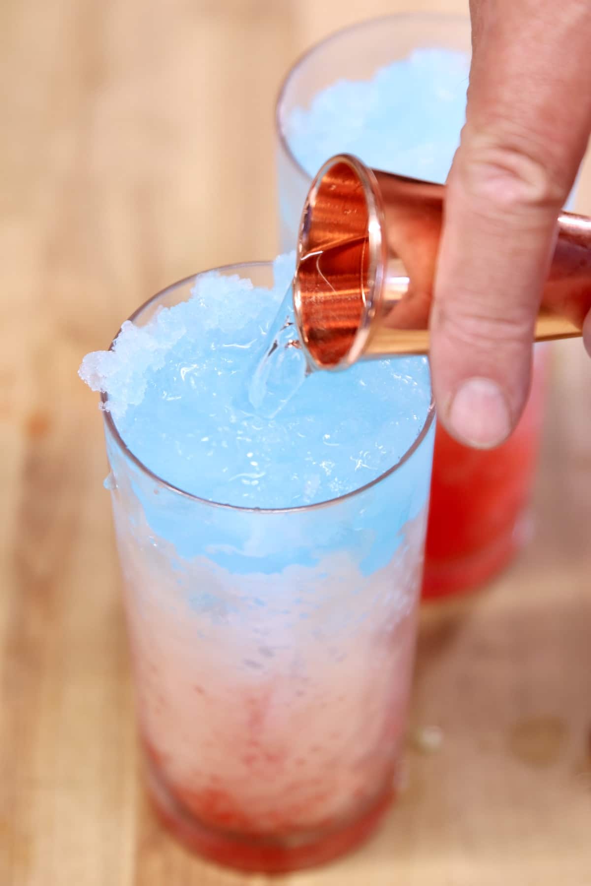 Pouring rum into a layered slush drink.