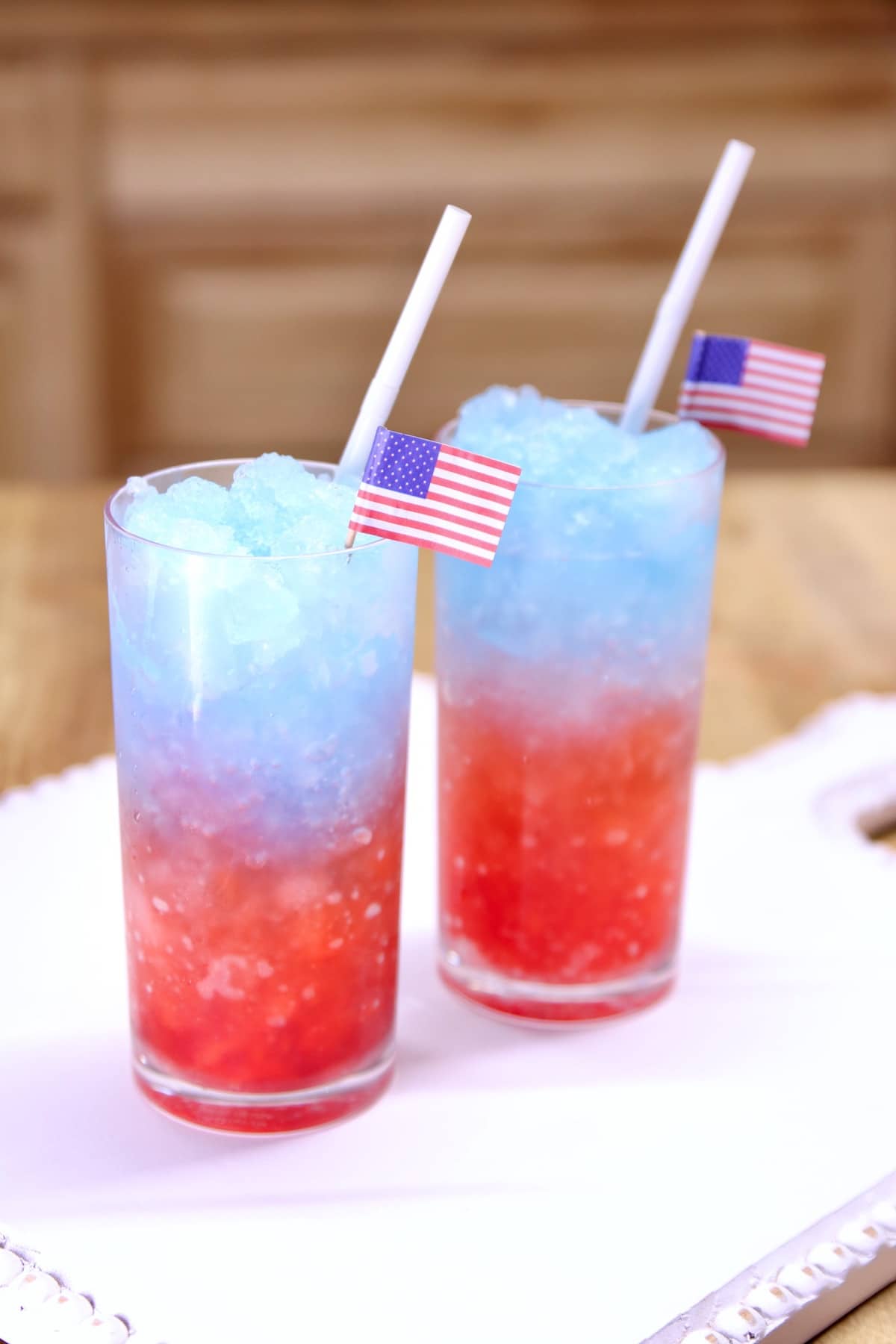Red, white and blue slush cocktail with American flag picks.