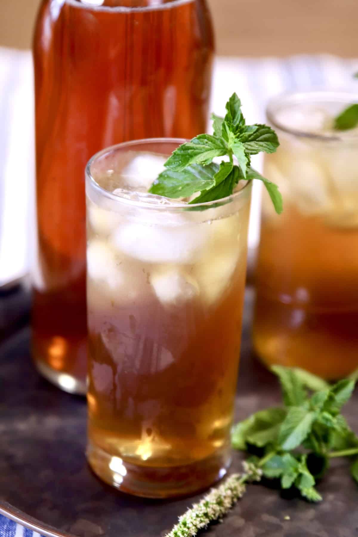 Glasses of spiked iced tea with mint garnish.