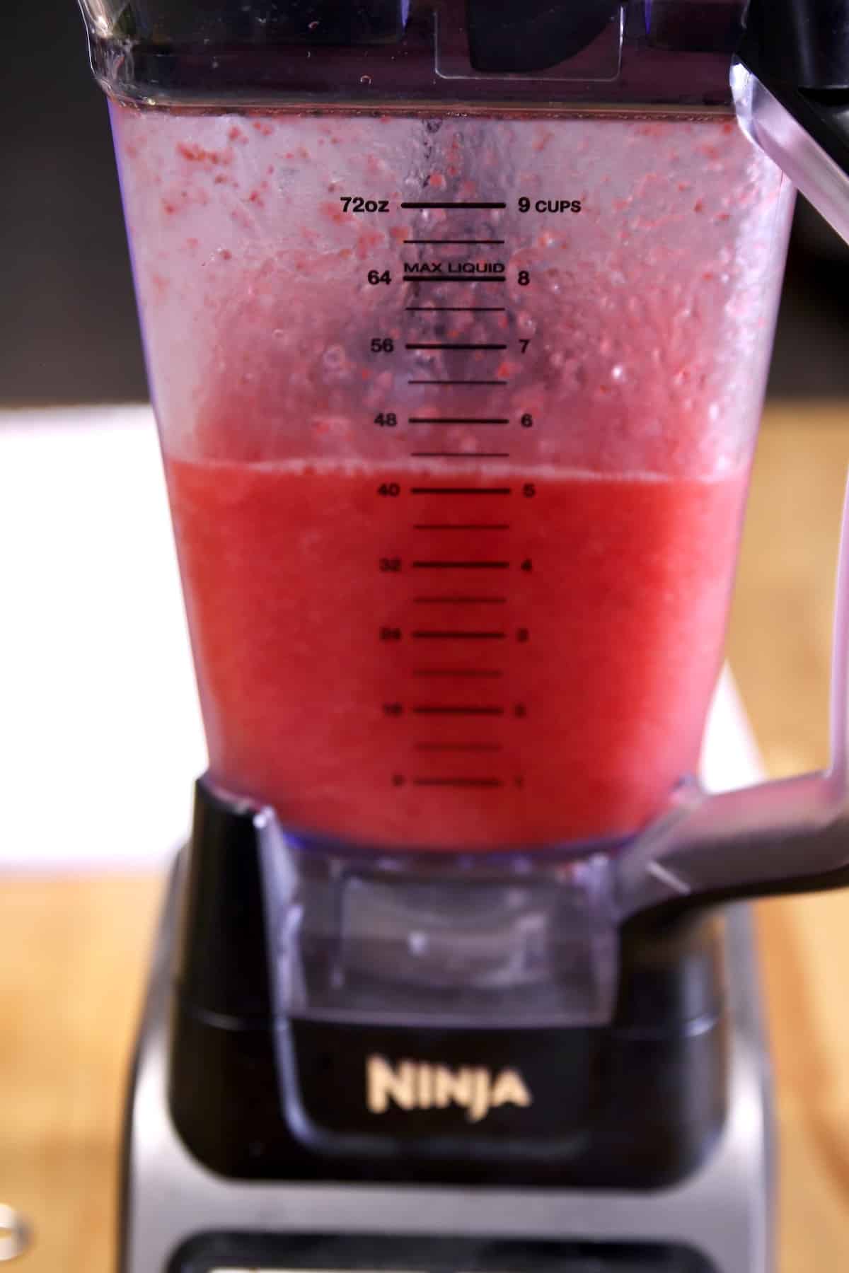 Strawberry rum cocktail in a blender.