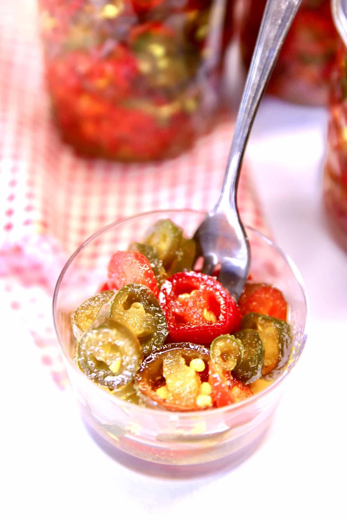 Small bowl and condiment fork with candied jalapenos.
