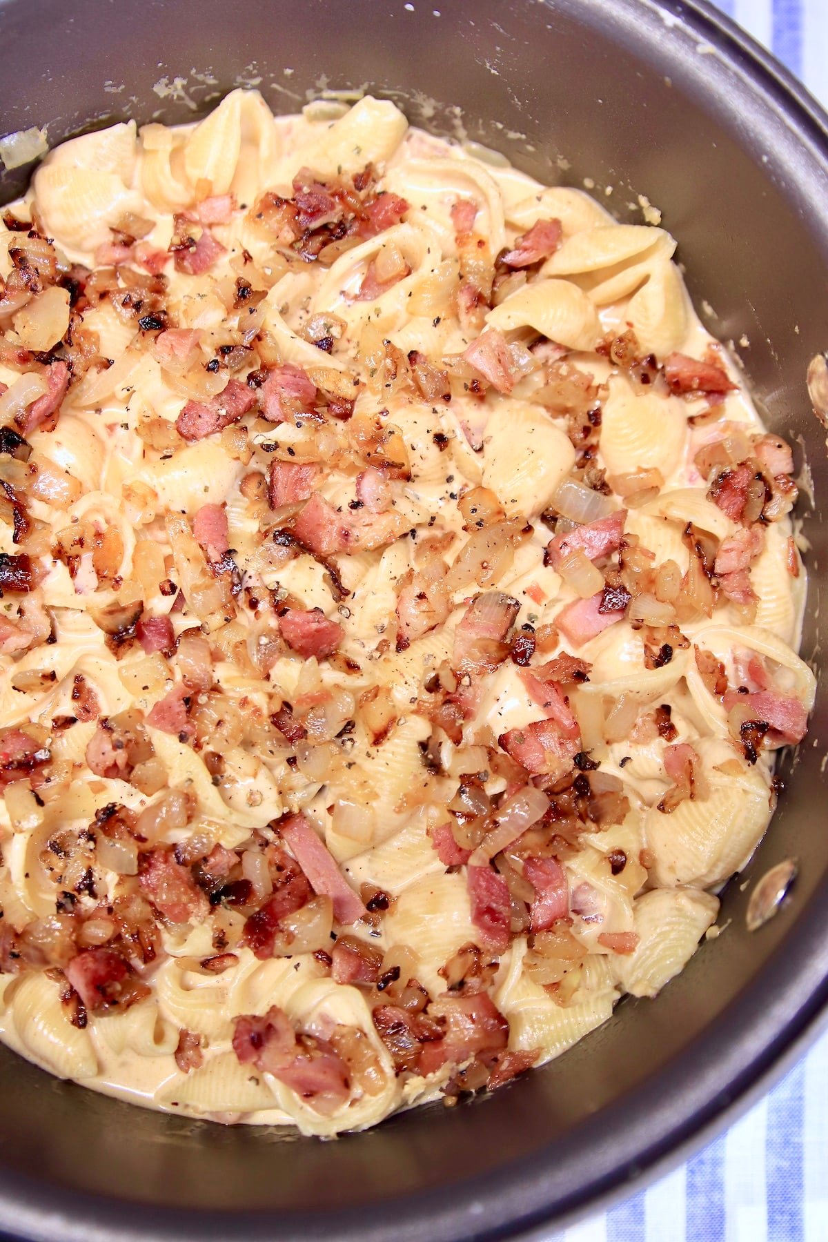 Ham and cheese pasta shells in a pan.