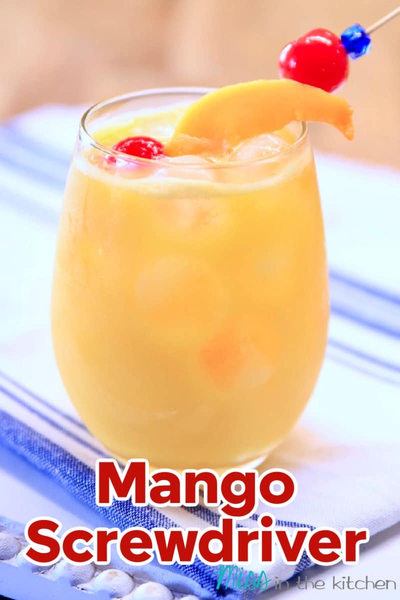 Mango and orange vodka drink, cherry and mango garnish.