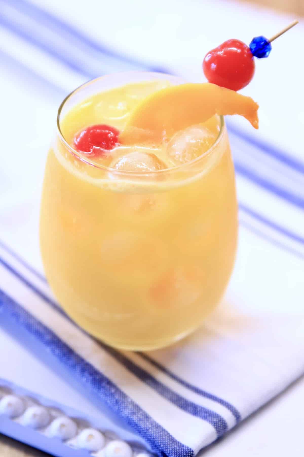Stemless wine glass with orange mango cocktail.