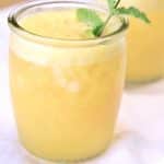 Pineapple Mango Rum Punch in a glass with mint garnish.