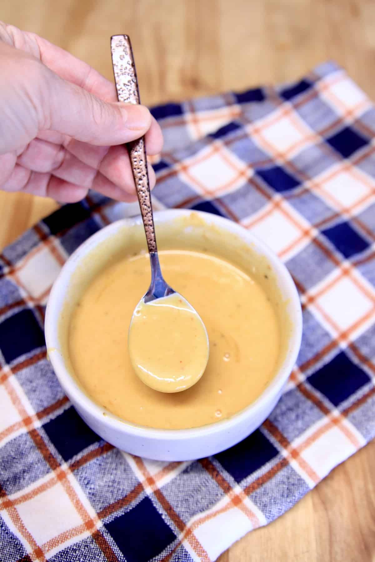Bowl of Chick Fil A Sauce with spoon dipping.