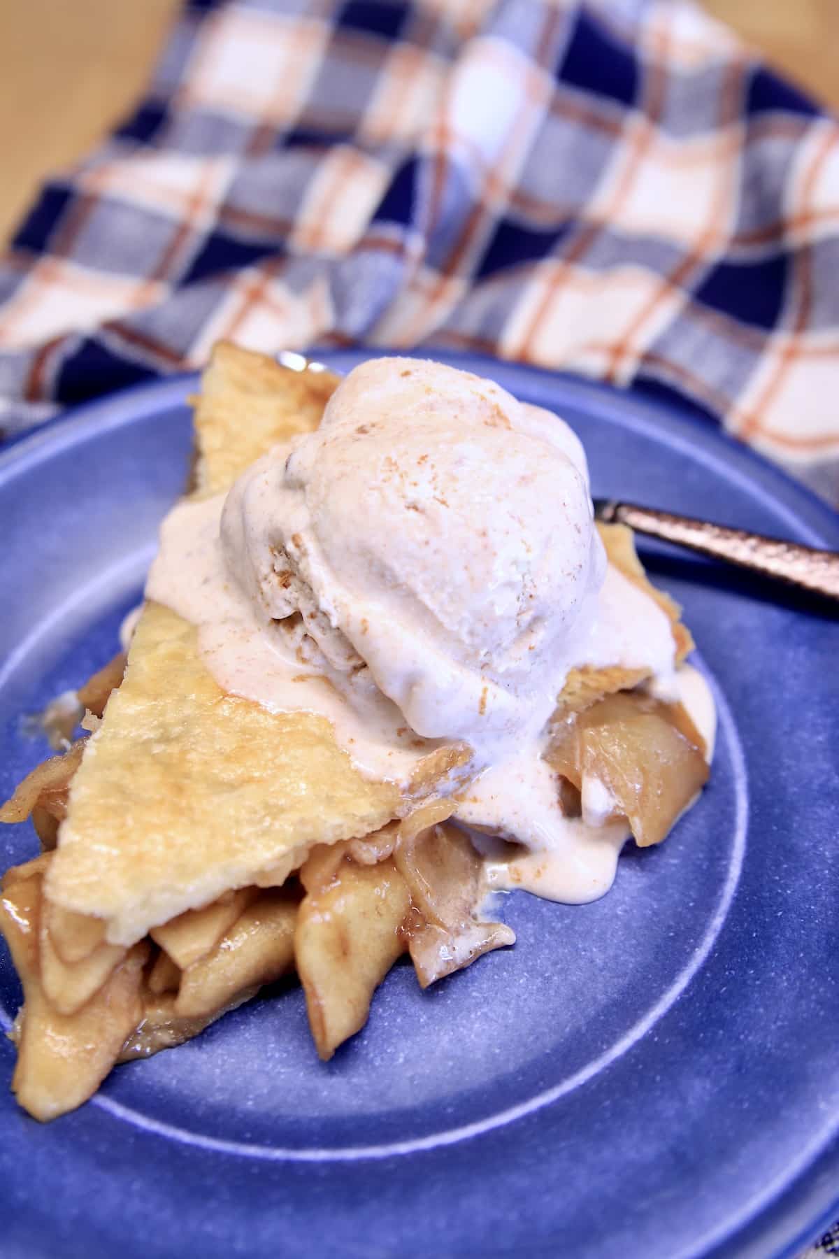 Apple pie slice with scoop of cinnamon ice cream.