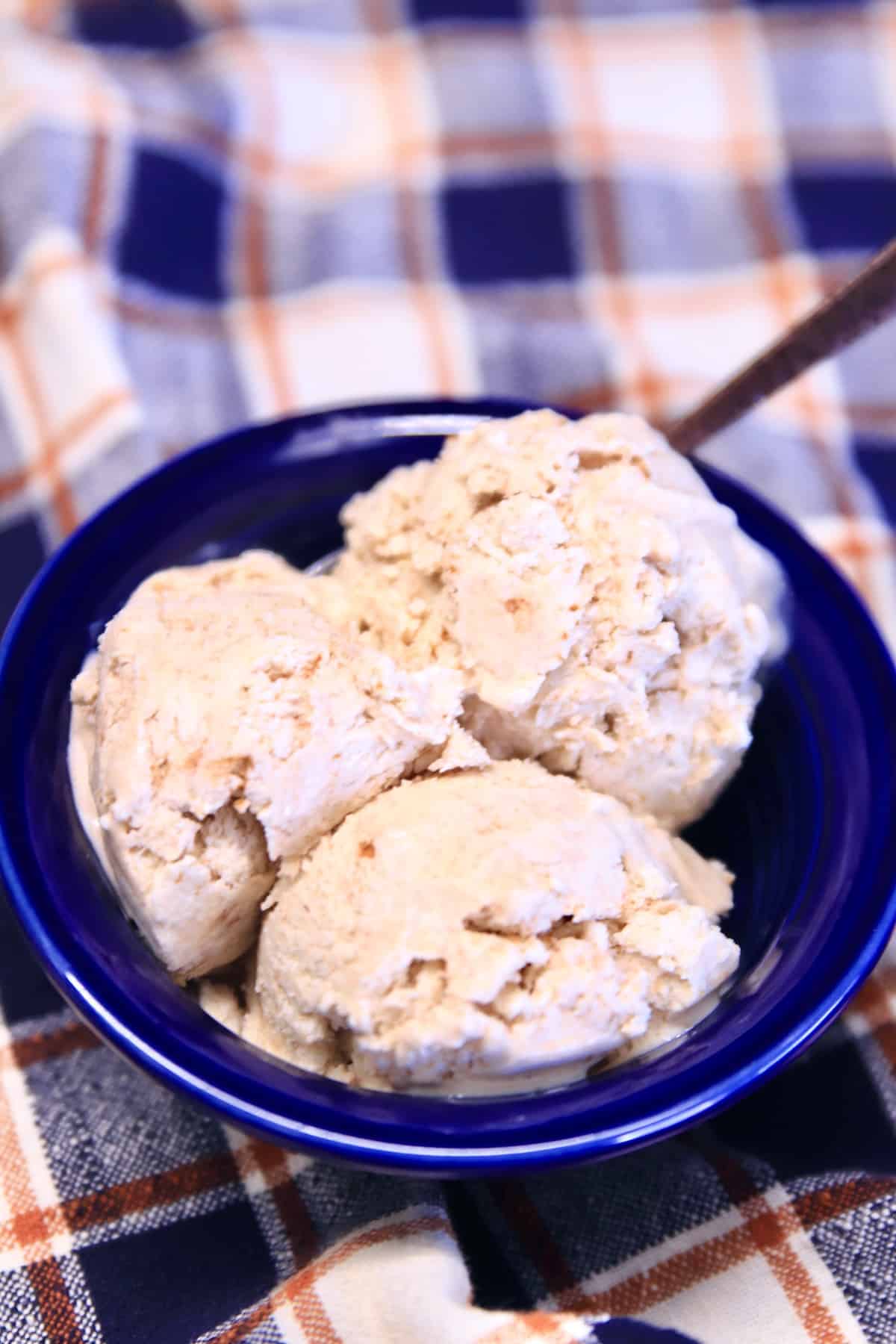 Bowl of 3 scoops of cinnamon ice cream with a spoon.