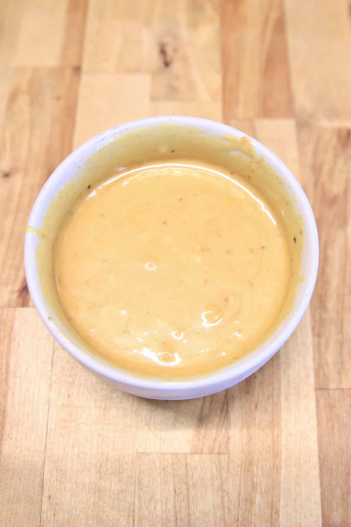 Bowl of Chick Fil A dipping sauce on wood counter.