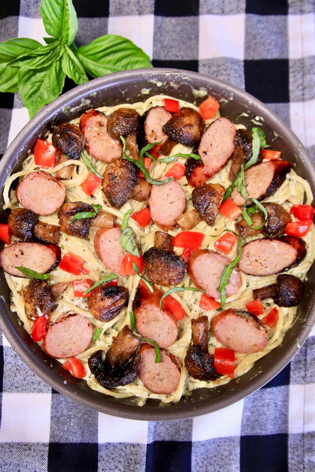 Pasta with sliced sausage, tomatoes. 