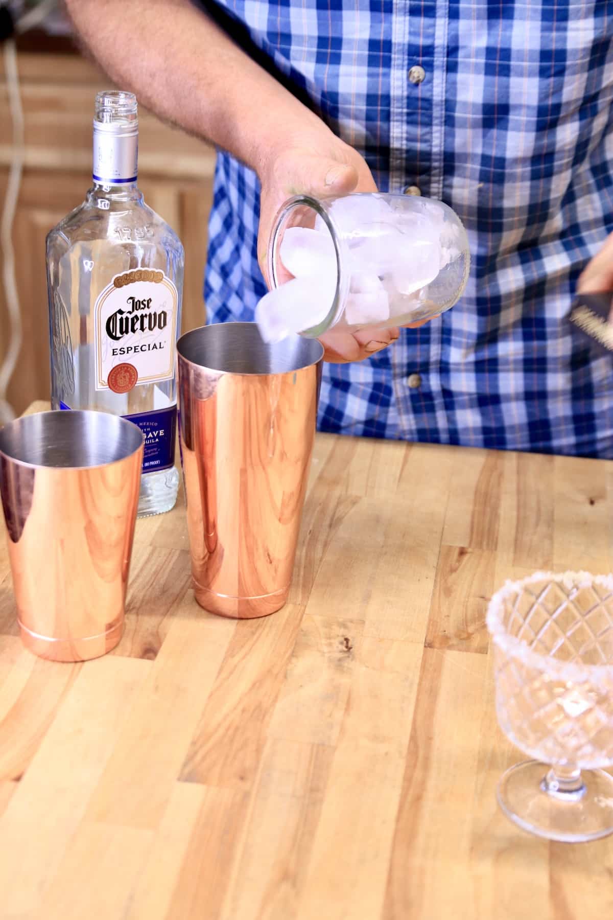 Pouring ice into a cocktail shaker.