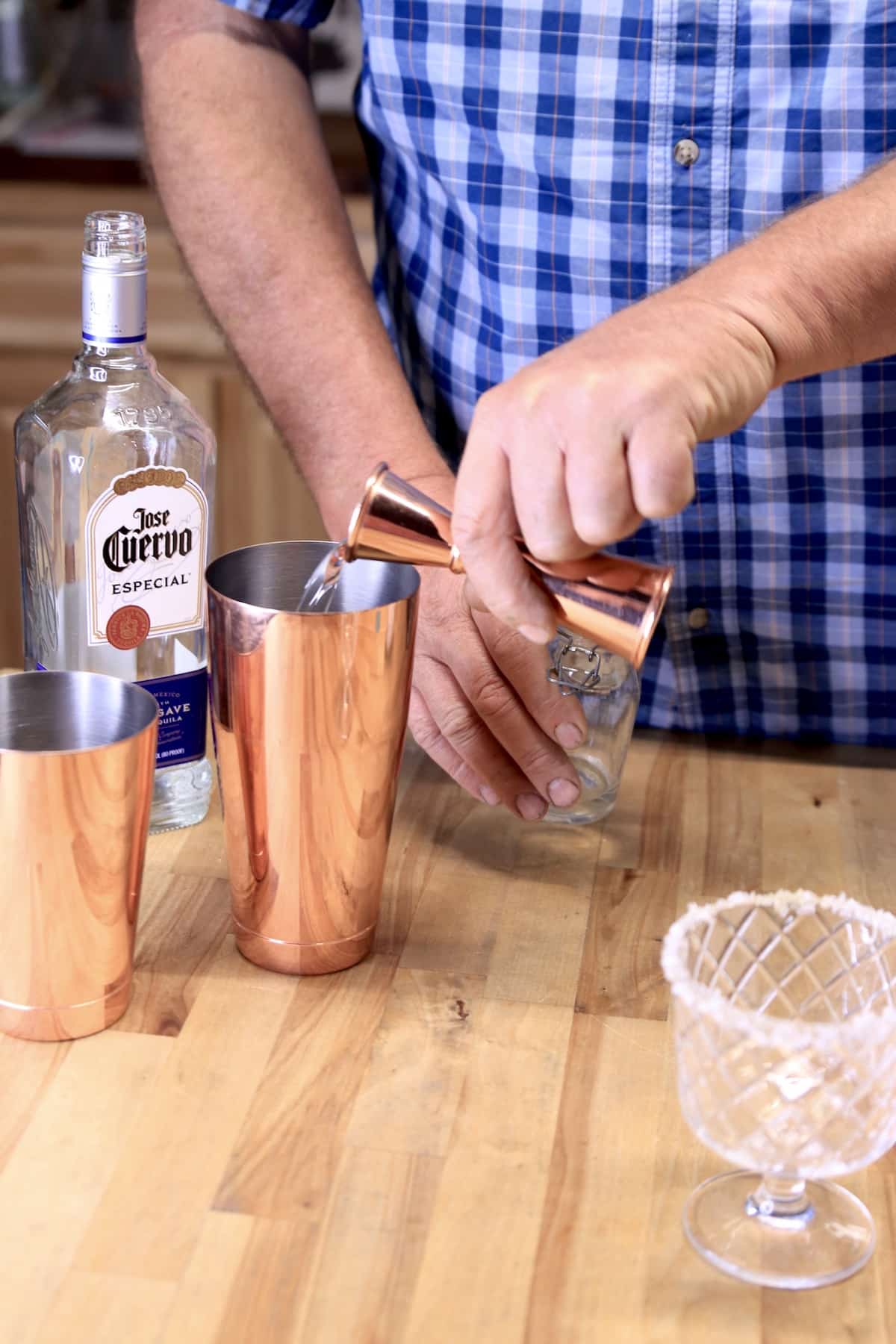 Pouring simple syrup into cocktail shaker.
