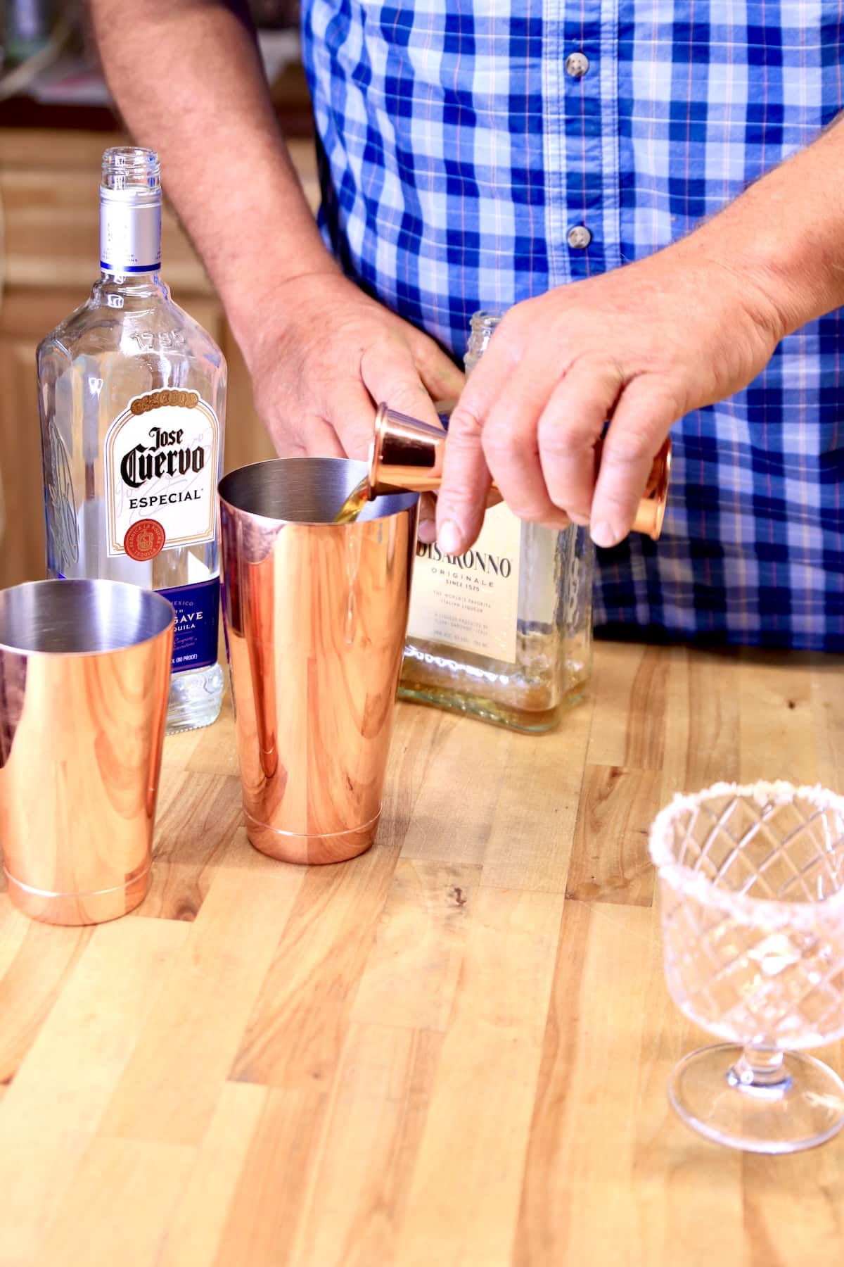 Pouring amaretto into cocktail shaker.