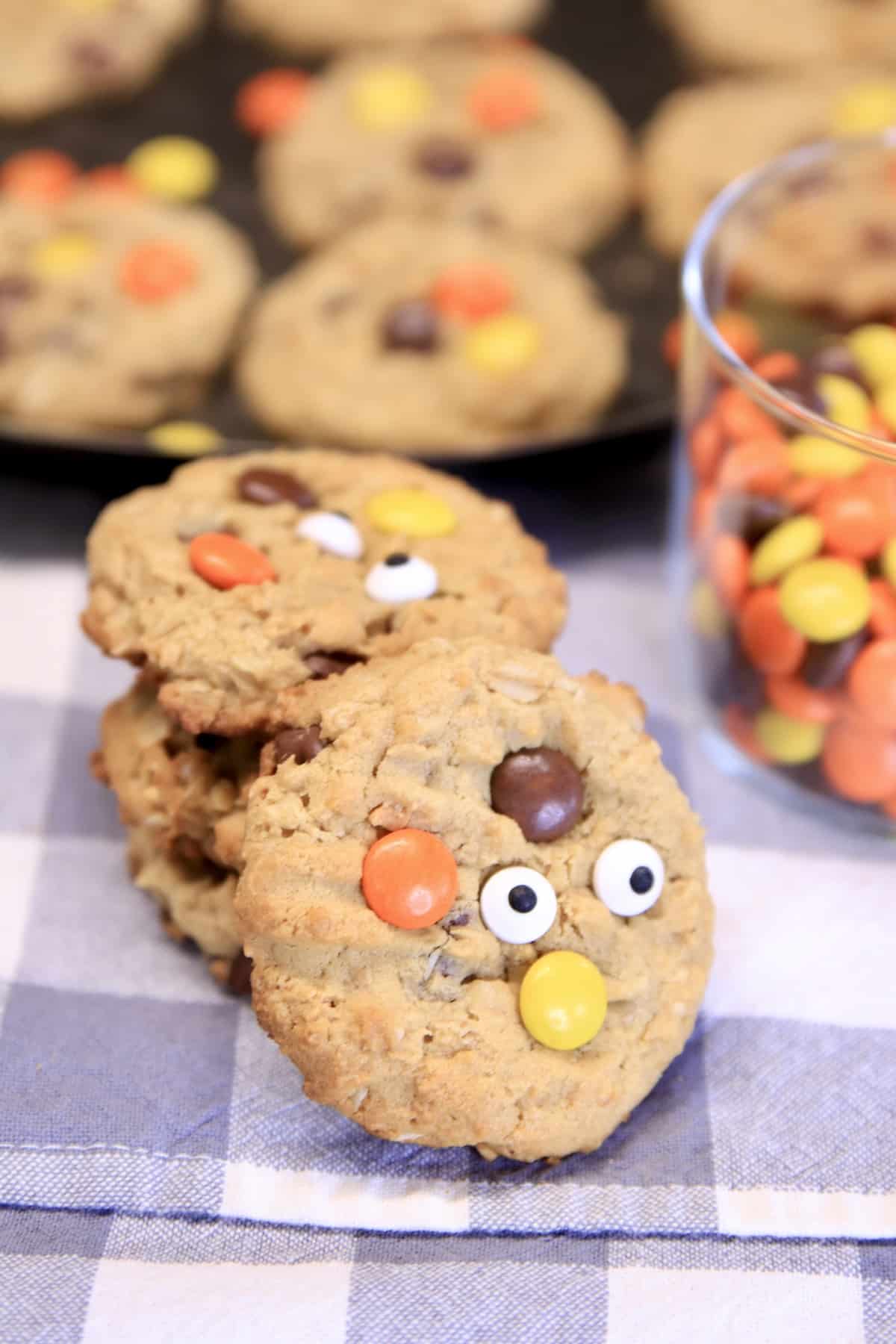 Reese's Pieces Monster Cookies with candy eyeballs for Halloween stacked.