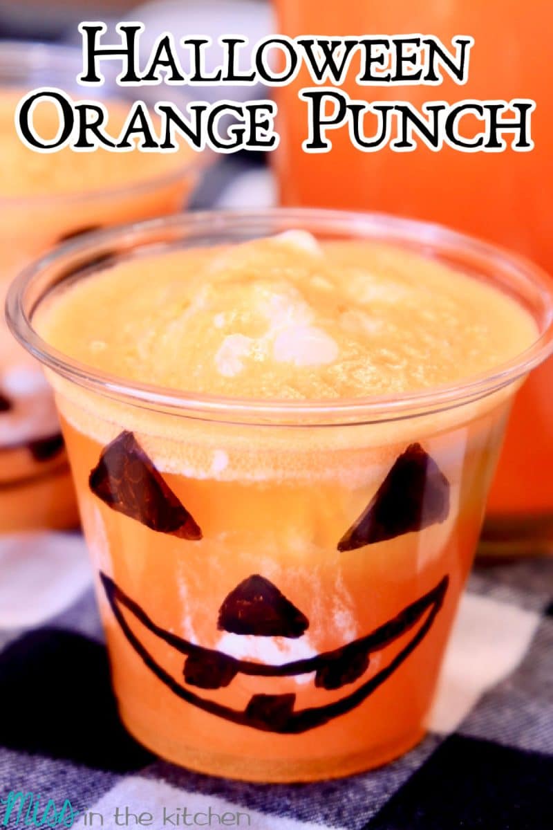 Halloween Orange Punch in a jack-o-latern glass, text overlay.